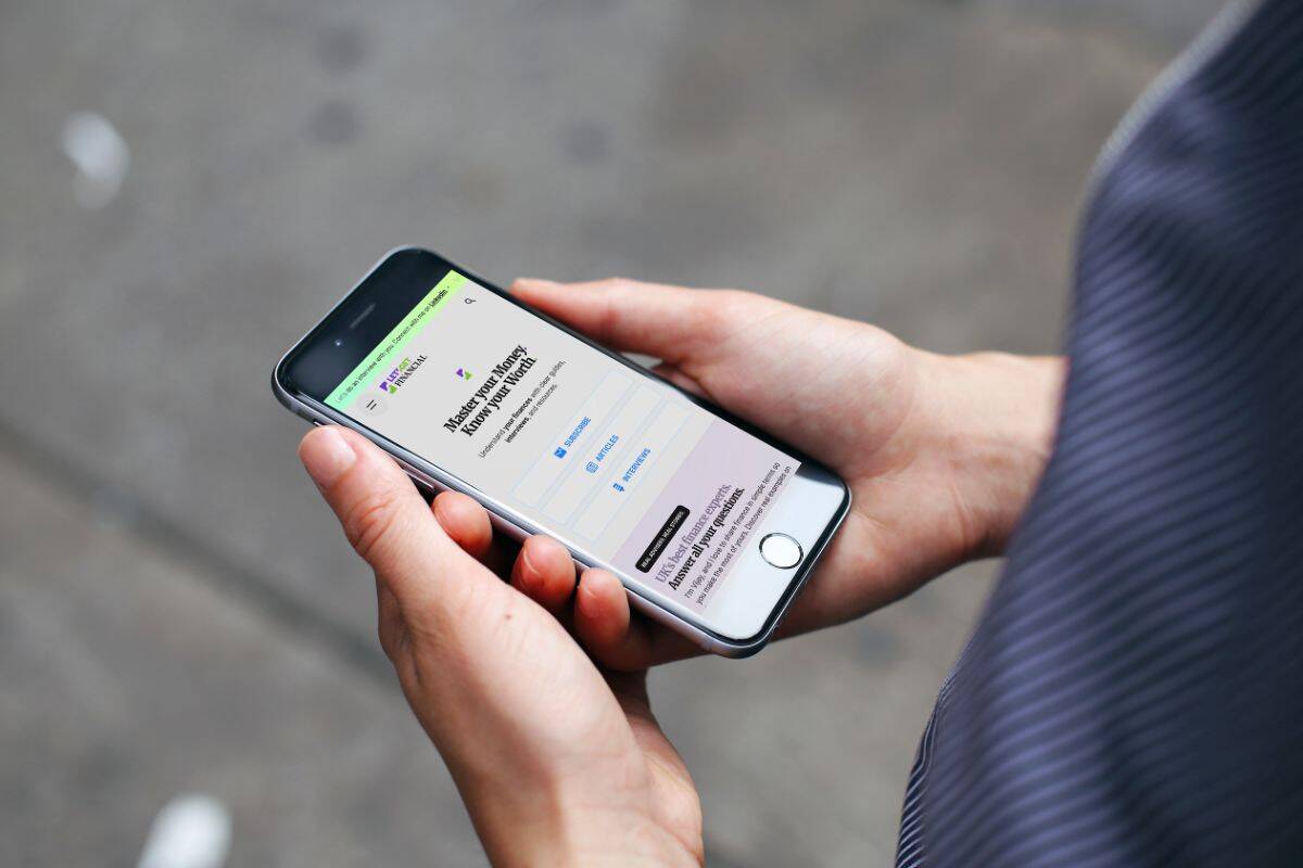 Person holding smartphone browsing Let’s Get Financial website